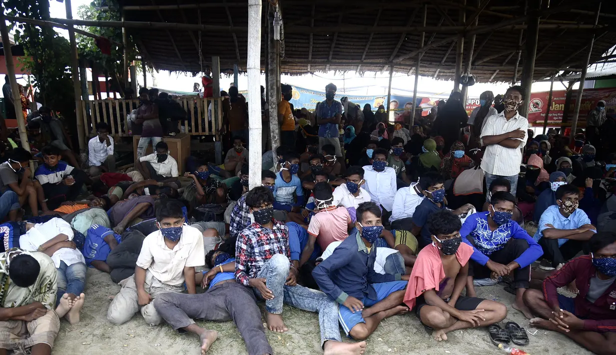 Pengungsi Rohingya beristirahat setelah perahu yang membawa mereka mendarat di Lhokseumawe, provinsi Aceh, Senin (7/9/2020). Hampir 300 Muslim Rohingya ditemukan di sebuah pantai di provinsi Aceh dan dievakuasi oleh militer, polisi dan Relawan. (AFP Photo/Rahmat Mirza)