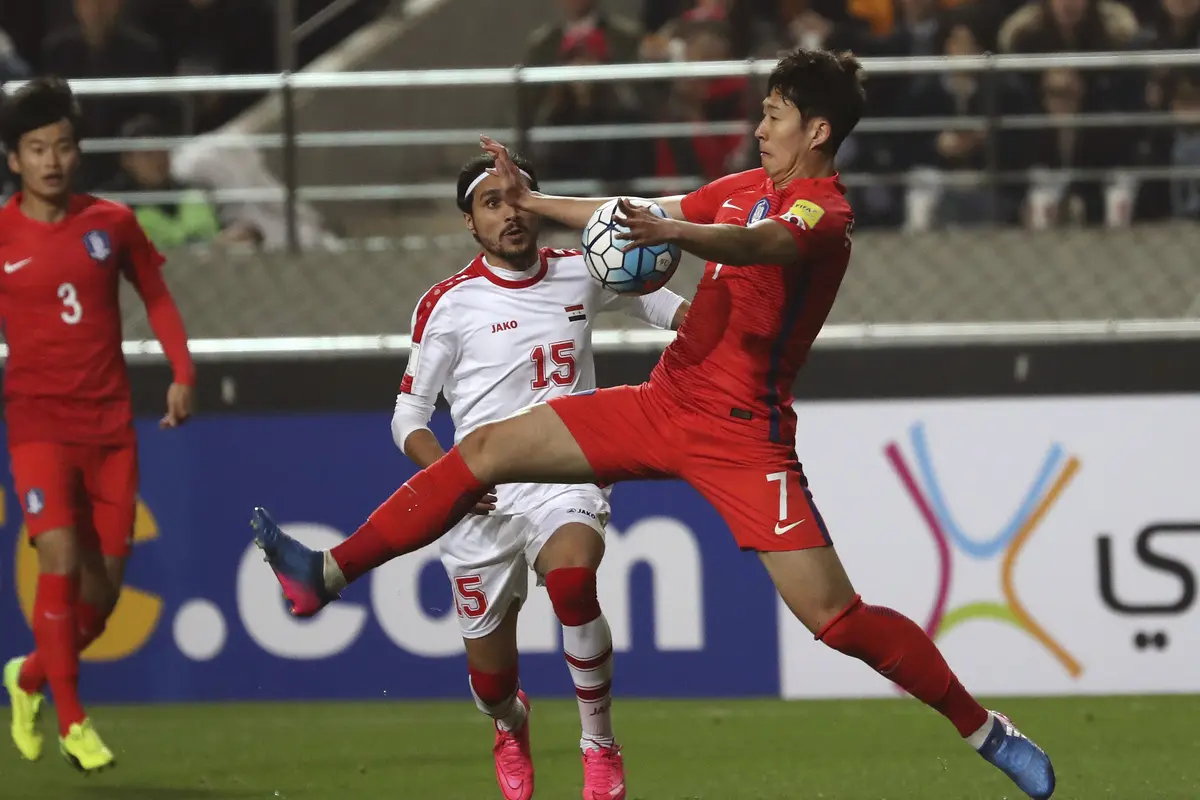 Bintang Timnas Korsel Son Heung-min (kanan) berebut bola dengan penggawa Suriah Alaa Al Shbbli pada laga kualifikasi Piala Dunia 2018 zona AFC di Seoul World Cup Stadium, Selasa (28//3/2017). 