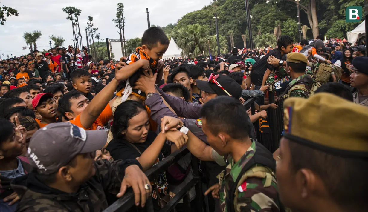Seorang anak dari suporter Persija Jakarta, The Jakmania, berusaha masuk ke dalam stadion jelang final Piala Presiden di sekitar SUGBK, Jakarta, Sabtu (17/2/2018). Persija akan menghadapi Bali United. (Bola.com/Vitalis Yogi Trisna)