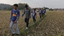 Penuh semangat para Bobotoh melintasi sawah menuju Stadion Si Jalak Harupat, Bandung. (Bola.com/Vitalis Yogi Trisna)