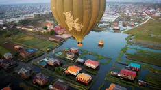 Balon udara terbang di atas rumah-rumah panggung kampung terapung Danau Inle, Negara Bagian Shan, Myanmar, Senin (18/2). Danau air tawar yang sangat luas ini menawarkan berbagai keindahan. (Ye Aung THU/AFP)