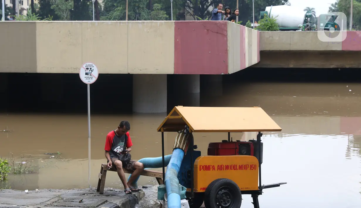 Warga melihat banjir yang mengenangi underpass Kemayoran, Jakarta, Minggu (2/2/2020). Banjir kembali merendam underpass Kemayoran, Jakarta Pusat. Akibatnya, akses jalur tersebut pun terputus alias tak bisa dilalui kendaraan. (Liputan6.com/Angga Yuniar)