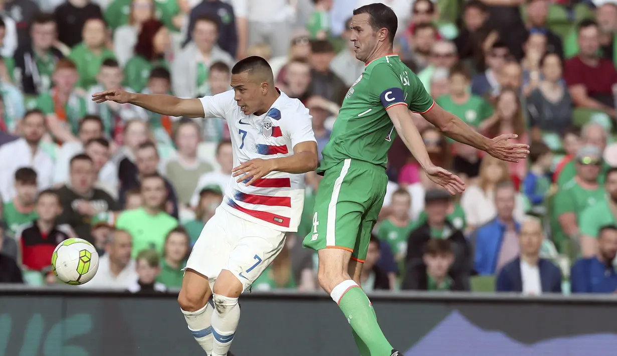 Pemain AS, Bobby Wood (kiri) mencoba melewati adangan pemain Irlandia, John O'Shea pada laga uji coba di Aviva Stadium, Dublin, (2/6/2018). Irlandia menang 2-1. (Brian Lawless/PA via AP)