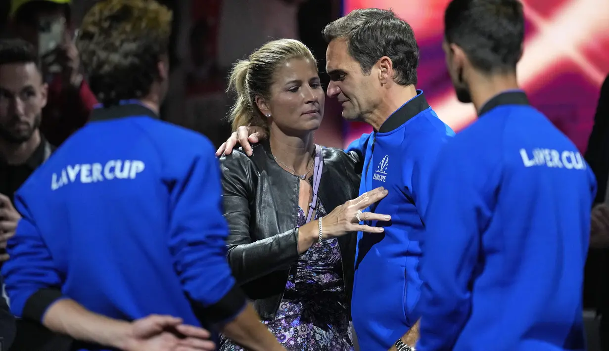 Roger Federer dipeluk oleh istrinya Mirka setelah bermain dengan Rafael Nadal dalam pertandingan ganda Piala Laver melawan Jack Sock dan Frances Tiafoe dari Tim Dunia di arena O2 di London, Jumat (23/9/2022). (AP Photo/Kin Cheung)
