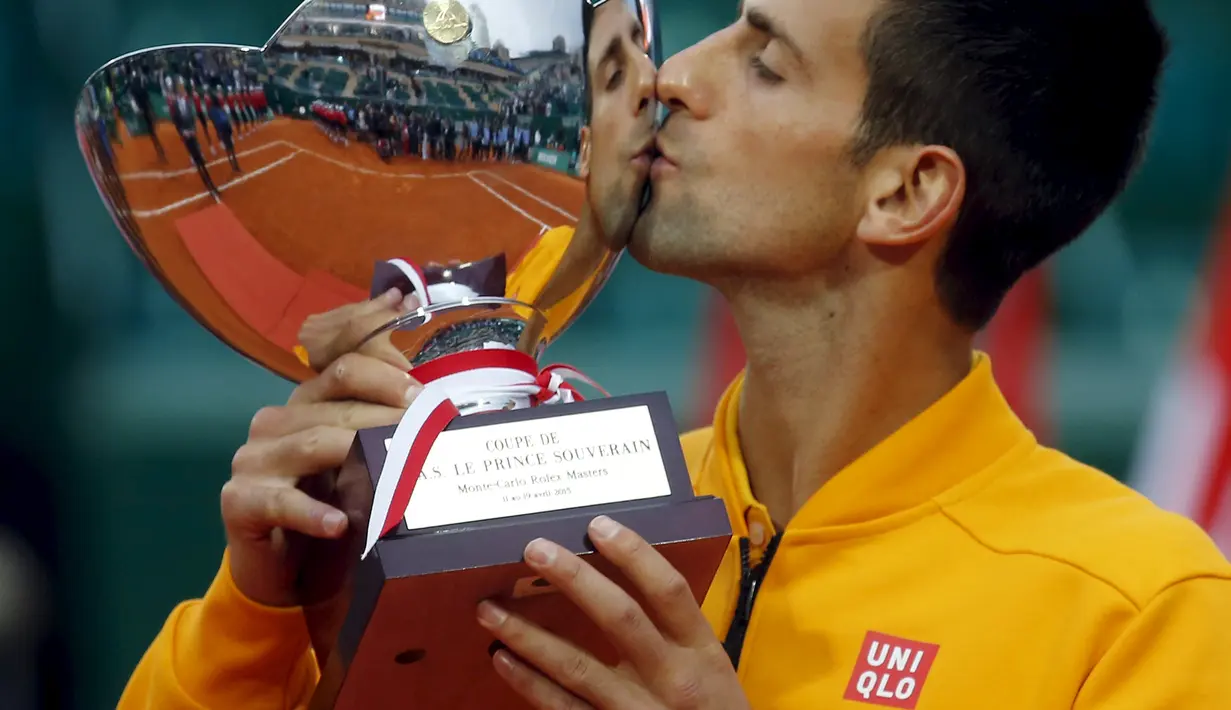 Novak Djokovic mencium trofi Monte Carlo Masters (REUTERS/Jean-Paul Pelissier)