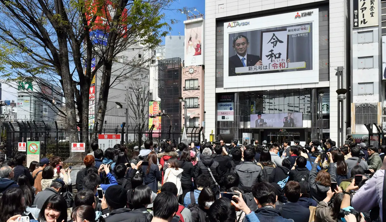 Orang-orang menonton layar besar yang menayangkan konferensi pers terkait pengumuman nama baru kekaisaran Jepang di Tokyo, Senin (1/4). Reiwa, menjadi nama era yang baru Jepang mulai 1 Mei 2019 setelah Kaisar Akihito turun takhta pada akhir April mendatang. (Kyodo News via AP)