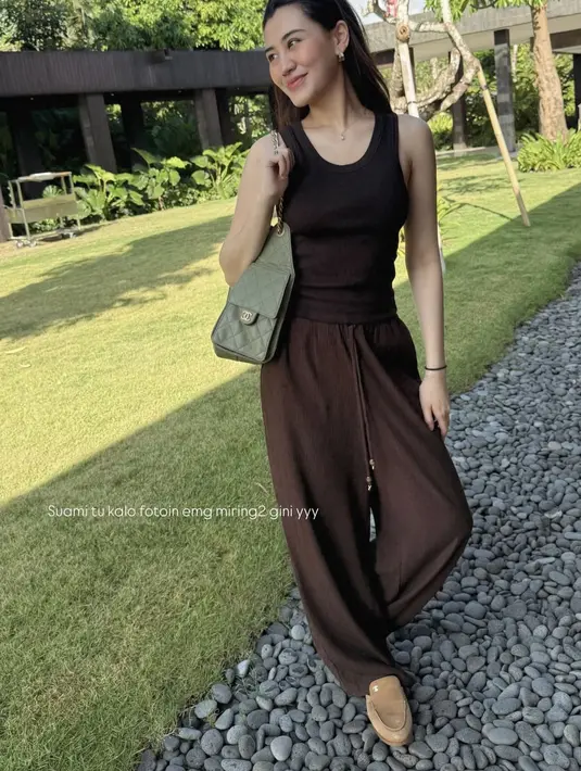 Berikutnya, Aaliyah mengenakan setelan coklat dari atasan tank top dipadukan celana panjang loose bertali sambil membawa tas Chanelnya. [@aaliyah.massaid]