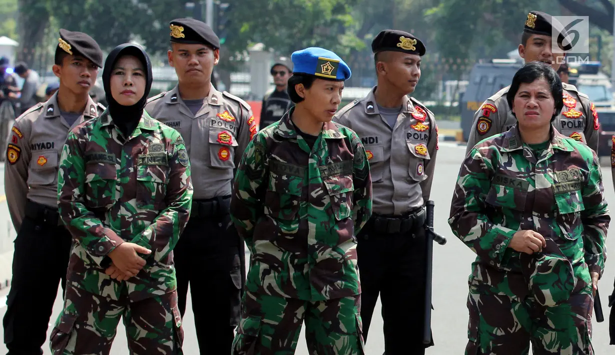 Aparat TNI wanita berjaga saat Hari Buruh Sedunia di depan Istana Negara, Jakarta, Selasa (1/5). Para buruh berbondong-bondong datang menuju Istana Kepresidenan membawa bendera dan atribut masing-masing serikat kerjanya. (Liputan6.com/Johan Tallo)