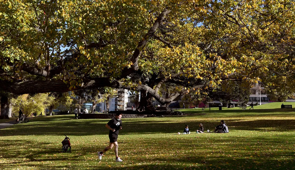 Seorang pria berolahraga di dalam taman kota di Melbourne, Australia (3/6/2021). Pihak berwenang mengumumkan Lockdown di Melbourne diperpanjang tujuh hari lagi ketika negara itu berusaha untuk membasmi sekelompok kasus Covid-19 di Melbourne. (AFP Photo/William West)