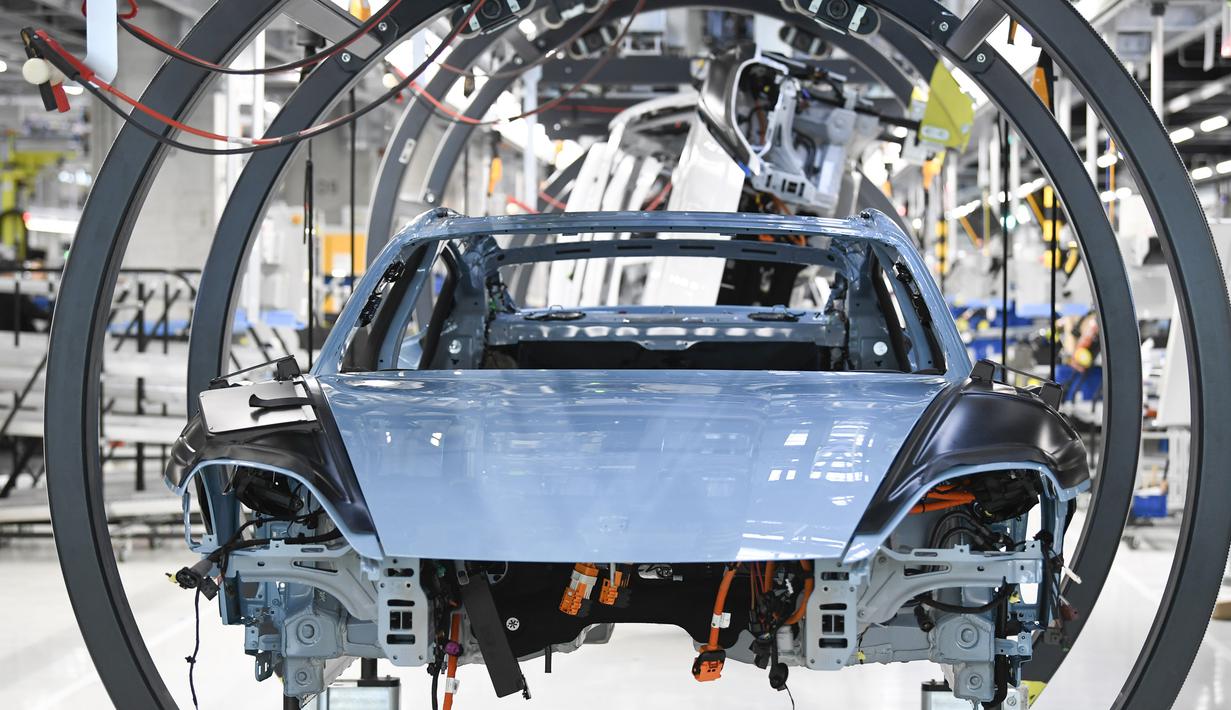 Rangka mobil listrik Porsche Taycan saat proses perakitan di pabrik perusahaan Porsche AG di Stuttgart, Jerman, Rabu (4/3/2020). Porsche Taycan merupakan mobil bertenaga listrik pertama  dari pembuat mobil mewah Jerman, Porsche AG. (AFP Photo/Thomas Kienzie)