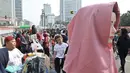 Warga melintasi lapak PKL saat car free day di MH Thamrin, Jakarta, Minggu (8/9/2019). Penutupan sebagian jalan akibat proyek revitalisasi trotoar membuat para PKL menggelar lapak hingga ke badan jalan sehingga menyebabkan aktivitas olahraga warga terhambat. (merdeka.com/Iqbal S. Nugroho)