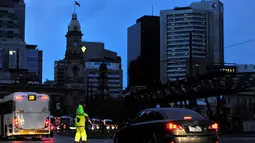 Polisi mengatur lalu lintas di kawasan pusat bisnis kota Adelaide, bagian Australia Selatan, Rabu (28/9). Seluruh wilayah itu gelap gulita dan warga tidak bisa melakukan kegiatan yang memerlukan arus listrik semalaman. (AAP/David Mariuz/via REUTERS)