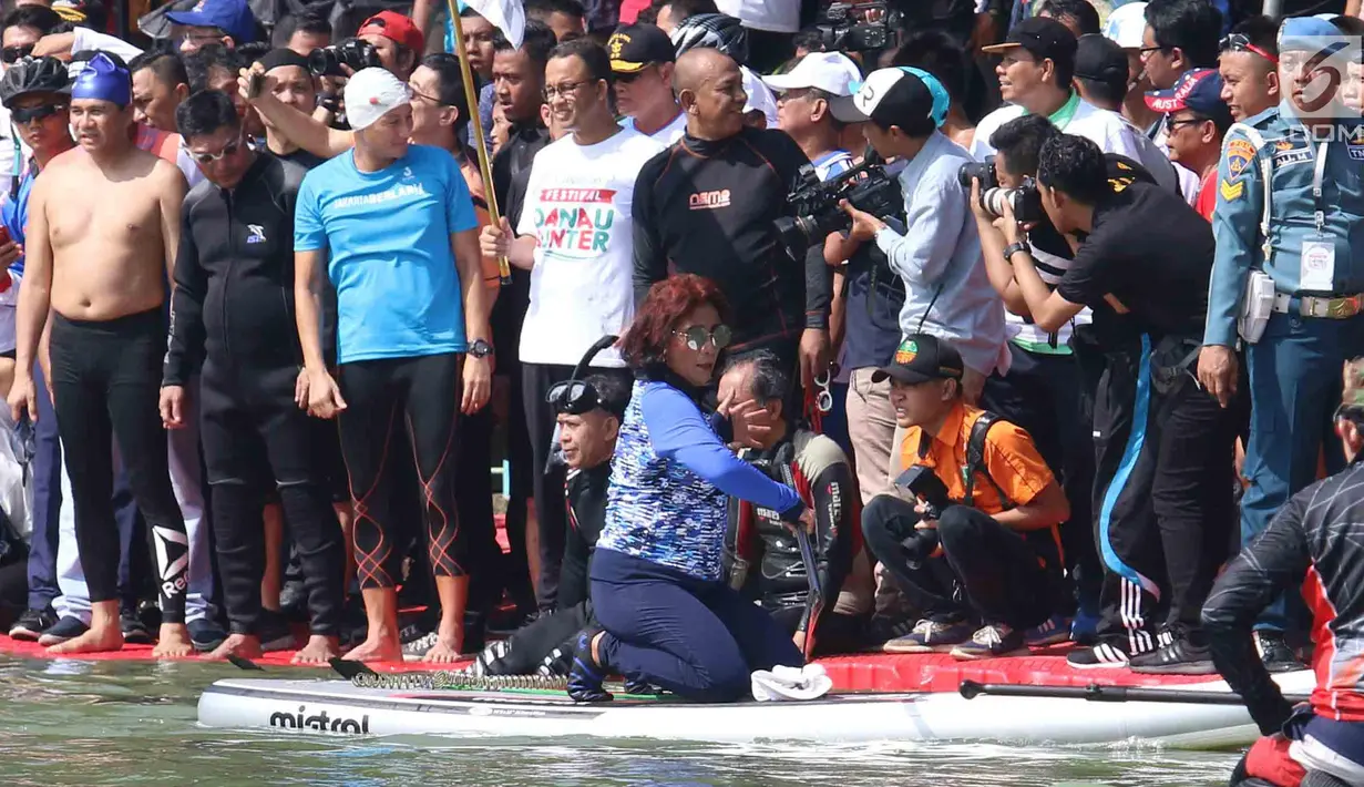Warga menyaksikan pertandingan antara Menteri KKP Susi Pudjiastuti dan Wagub DKI Jakarta Sandiaga Uno mengarungi danau sunter selama Festival Danau Sunter di Jakarta, Minggu (25/2). (Liputan6.com/Angga Yuniar)