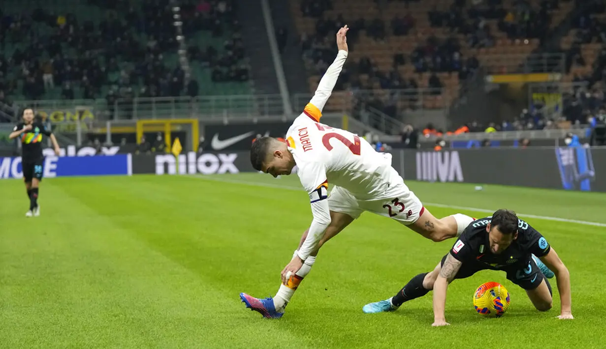 Pemain Inter Milan Hakan Calhanoglu (kanan) memperebutkan bola dengan pemain AS Roma Gianluca Mancini pada pertandingan sepak bola Coppa Italia di Stadion San Siro, Milan, Italia, 8 Februari 2022. Inter Milan menang 2-0. (AP Photo/Antonio Calani)