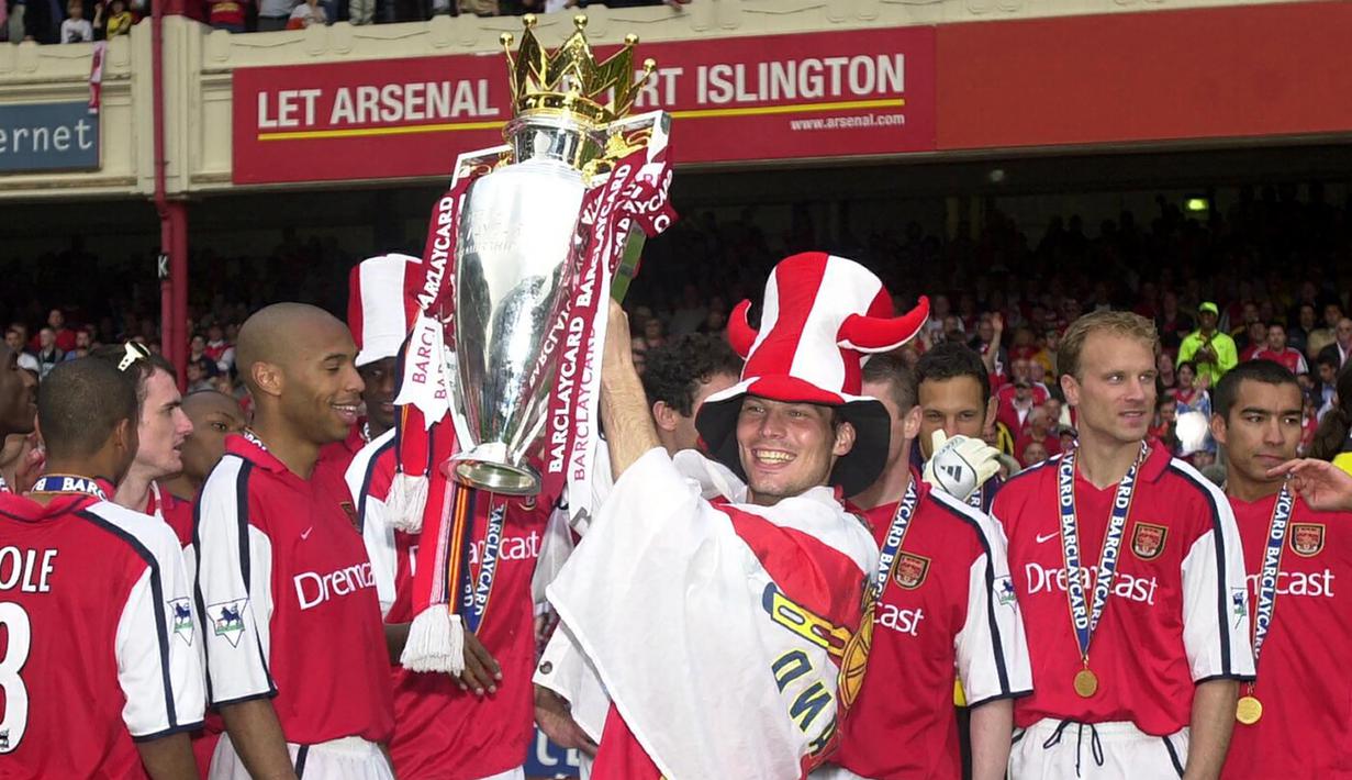 Gelandang Arsenal, Fredrik Ljungberg mengangkat trofi dalam perayaan gelar juara Liga Inggris 2001/2002 usai laga menghadapi Everton di Highbury Stadium, London (11/5/2002). Arsenal menjadi klub kedua yang mampu menyandingkan raihan trofi Liga Inggris dengan Piala FA dalam satu musim di Era Premier League. The Gunners tercatat pernah dua kali meraih trofi Liga Inggris dan Piala FA dalam satu musim, yaitu pada 1997/1998 dan 2001/2002. (AFP/Nicolas Asfouri)