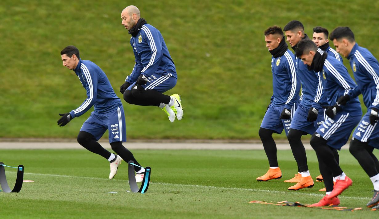 Angel Di Maria (kiri) dan Javier Mascherano melompat sesuai instruksi pelatih pada sesi latihan di City Football Academy, Manchester, (20/3/2018). Argentina akan melawan Italia pada laga persahabatan di Etihad Stadiu. (AFP/Anthony Devlin)