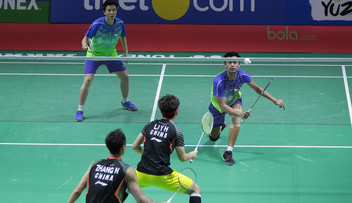 Tontowi Ahmad mengecoh pasangan China, Zhang Nan/Li Yinhui pada perempat final Indonesia Open 2018 di Istora Senayan, Jakarta, (6/6/2018). Tontowi/Liliyana menang 21-17, 21-14. (Bola.com/Nick Hanoatubun)