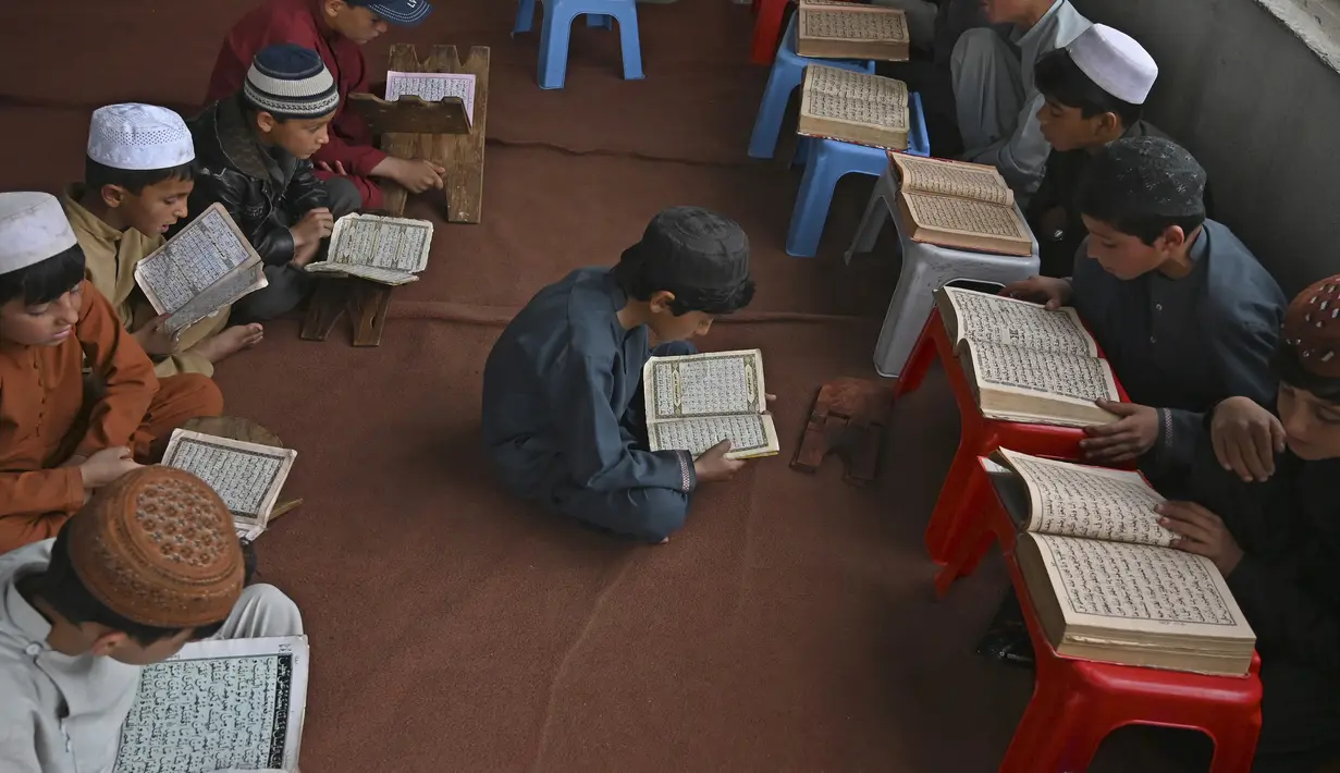 Anak-anak membaca Alquran selama bulan suci Ramadhan di sebuah masjid di pinggiran Kabul, Afghanistan, Selasa (27/4/2021).  Bulan Ramadhan menjadi momen untuk memperbanyak amalan, termasuk ketekunan menjalani tadarus Alquran. (WAKIL KOHSAR / AFP)