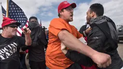 Ekspresi pendukung Presiden Donald Trump saat bentrok dengan pengunjuk rasa anti-Trump di Huntington Beach, California (25/3). (Mindy Schauer / The Orange County Register via AP)
