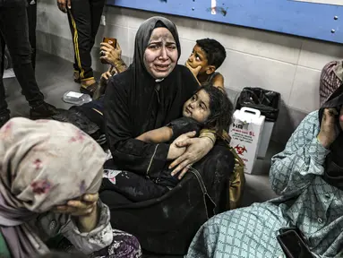 Warga Palestina yang terluka duduk di Rumah Sakit Shifa di Kota Gaza, Jalur Gaza tengah, setelah tiba dari Rumah Sakit al-Ahli menyusul ledakan di sana, Selasa, 17 Oktober 2023. (AP Photo/Abed Khaled)