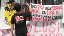 Seorang pengunjuk rasa memasang spanduk berisi tuntutan di pagar gedung DPR saat mengikuti aksi Aliansi Masyarakat Pati Bersatu (AMPB) di Jakarta, Kamis (27/8/2026). (KLY/Budy Santoso)