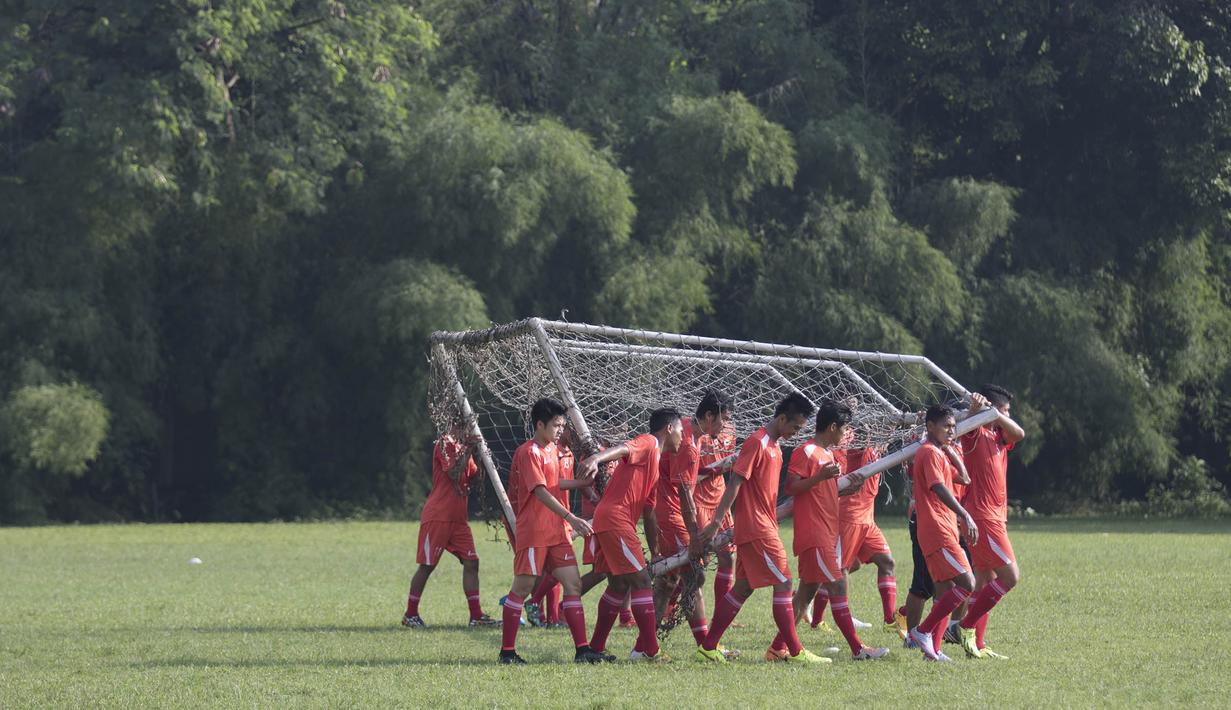 Para pemain Persija mengangkat gawang saat latihan jelang babak 8 besar Piala Jenderal Sudirman di Lapangan Sawangan, Depok, Jawa Barat, Senin (7/12/2015). (Bola.com/Vitalis Yogi Trisna) 