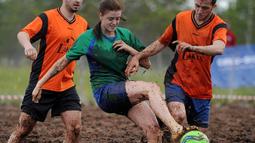 Pemain sepak bola rawa berebut bola dalam turnamen memperebutkan Piala Rusia yang berlangsung di Saint Petersburg, Rusia. Sabtu (27/6). (AFP PHOTO/OLGA MALTSEVA)