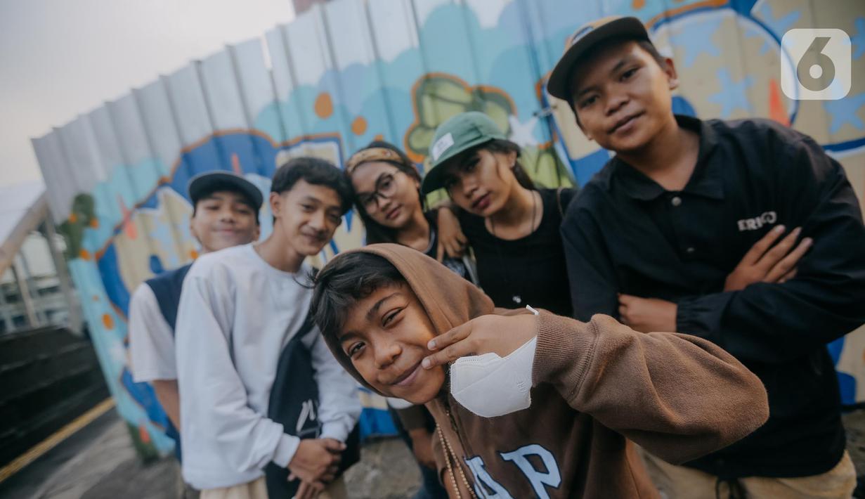 Para remaja dari berbagai daerah di pinggiran Jakarta berpose di Taman Sudirman, Jakarta, Rabu (6/7/2022). Tempat ini viral karena jadi ajang adu fashion anak Citayam, Bekasi hingga Bojong Gede. Mereka mengenakan kemeja flanel oversize, celana model 90-an seperti boot cut
atau cutbray, sneakers klasik, dan topi. (Liputan6.com/Faizal Fanani)