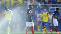 Penyerang Timnas Prancis, Kylian Mbappé, mendinginkan tubuhnya saat jeda minum (hydration break) dalam pertandingan 32 besar Piala Dunia 2026 antara Prancis melawan Swedia di New York New Jersey Stadium, East Rutherford, New Jersey, pada 30 Juni 2026. (Dan Mullan/Getty Images/AFP)