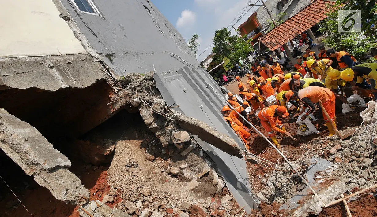 Petugas gabungan membersihkan puing longsoran di Perumahan Pesona Kalisari, Pasar Rebo, Jakarta, Selasa (27/11). Sebelumnya, rumah milik ketua RT setempat terkena bencana longsor pada Senin (26/11) karena hujan deras. (Liputan6.com/Herman Zakharia)