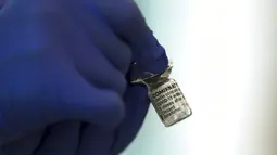 Seorang pekerja medis memegang vaksin Pfizer-BioNTech COVID-19 di Tokyo Medical Center, Tokyo, Jepang, Rabu (17/2/2021). Jepang memulai kampanye vaksinasi COVID-19 dengan suntikan COVID-19 pertama diberikan kepada petugas kesehatan. (Behrouz Mehri/Pool Photo via AP)