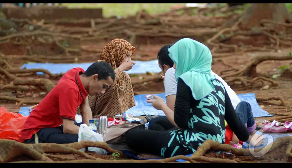 Sebuah keluarga sedang bersantai di sekitar taman Margasatwa Ragunan, Jakarta Selatan, Selasa (29/07/2014) (Liputan6.com/Miftahul Hayat) 