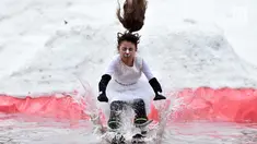 Seorang peserta dengan mengenakan kostum melompat ke dalam kolam sebagai bagian dari kompetisi komik 'Californication 9.0' di kota Logoisk, utara Minsk, Belarus, 7 April 2019. Sebanyak 8 peserta dengan kostum unik berseluncur salju untuk merayakan  akhir musim dingin. (Sergei GAPON / AFP)
