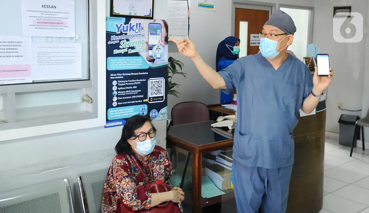 Dokter Desman Siahaan memberikan sosialisasi langsung mengenai tata cara rumah sakit rujukan kepada pasien BPJS Kesehatan yang sedang antre berobat di Faskes Tingkat 1 Klinik Kesehatan Prima Husada di Depok, Jawa Barat, Senin (23/5/20222). Sejumlah terobosan saat ini dilakukan paramedis di Faskes Tingkat 1, diantaranya penilaian peserta program JKN melalui fitur Kessan (Kesan Pesan Peserta Setelah Layanan)  dalam aplikasi Mobile JKN. (merdeka.com/Arie Basuki)
