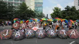 Sejumlah payung dirangkai membentuk sebuah tulisan 'Jaga Jakarta'   saat aksi simpatik di kawasan Bunderan HI, Jakarta, Minggu   (23/11/2014). (Liputan6.com/Herman Zakharia)