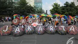 Sejumlah payung dirangkai membentuk sebuah tulisan 'Jaga Jakarta'   saat aksi simpatik di kawasan Bunderan HI, Jakarta, Minggu   (23/11/2014). (Liputan6.com/Herman Zakharia)