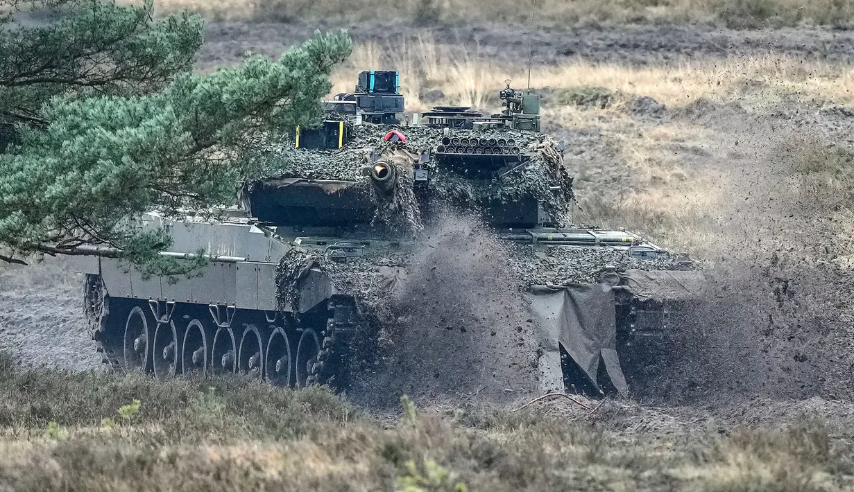 Sebuah tank Leopard 2 beraksi saat kunjungan Menteri Pertahanan Jerman Boris Pistorius ke batalyon tank Bundeswehr 203 di Field Marshal Rommel Barracks, Augustdorf, Jerman, 1 Februari 2023. Setelah keputusan pemerintah Jerman untuk mengirimkan 14 tank Leopard 2 ke Ukraina, kemampuan tank tempur utama Leopard 2A6 ditampilkan pada presentasi di Augustdorf. (AP Photo/Martin Meissner)