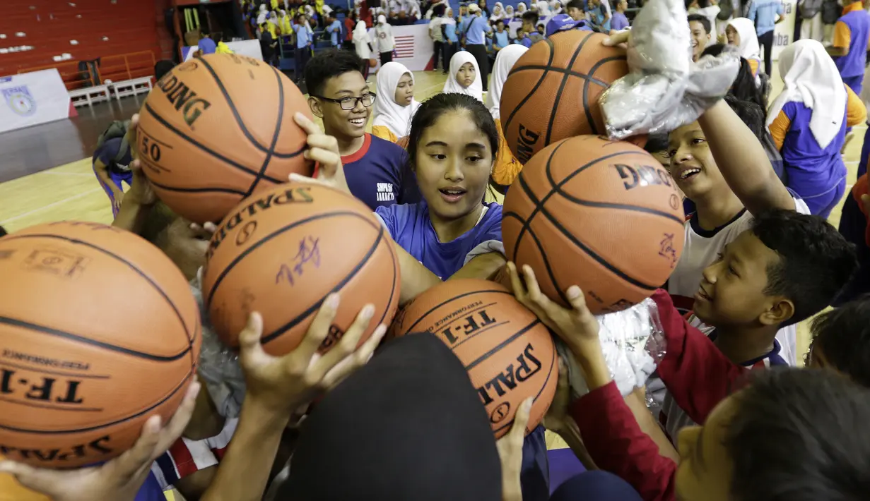 Ratusan anak-anak saat berebut tandan tangan Vanissa Renata saat mengikuti coaching clinic bersama Jr. NBA di GOR Soemantri Brodjonegoro, Kuningan, Jakarta, Kamis (17/10). Jr. NBA dengan Pemprovi DKI Jakarta padukan kurikulum olahraga basket dan pengembangan kebugaran. (Bola.com/Yoppy Renato)