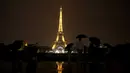 Sejumlah wisatawan menikmati pemandangan Menara Eiffel yang diterangi lampu dari Trocadero Plaza di Paris, Prancis (1/9).( AFP Photo/Ludovic Marin)
