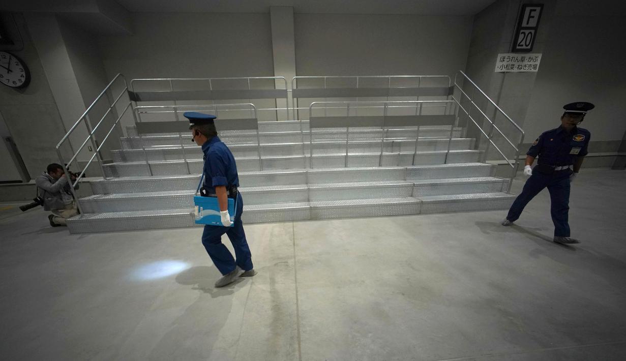 Petugas keamanan memeriksa bagian pasar ikan Toyosu sebelum upacara pembukaan di Tokyo, Kamis (13/9). Disini akan menjadi lokasi baru untuk Pasar Ikan Tsukiji yang jadi destinasi wisata favorit yang telah dibuka sejak tahun 1935. (AP/Eugene Hoshiko)