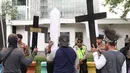Massa membawa atribut salib dalam unjuk rasa di depan Kedubes AS, Jakarta, Kamis (27/12). Mereka menuntut Dubes AS Joseph R. Donovan Jr bertanggungjawab atas dugaan pelanggaran HAM yang dilakukan oleh PT Freeport Indonesia. (Liputan6.com/Angga Yuniar)