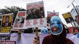 Mahasiswa mengenakan topeng dan membawa poster saat aksi demonstrasi di depan Kedutaan Besar (Kedubes) China, Jakarta, Jumat (30/9/2022). Dalam demo tersebut mahasiswa menuntut pemerintah China untuk menghentikan kekerasan terhadap umat muslim di China khususnya di Uighur serta masyarakat Tibet, Mongolia, Hongkong dan Taiwan. (Liputan6.com/Johan Tallo)