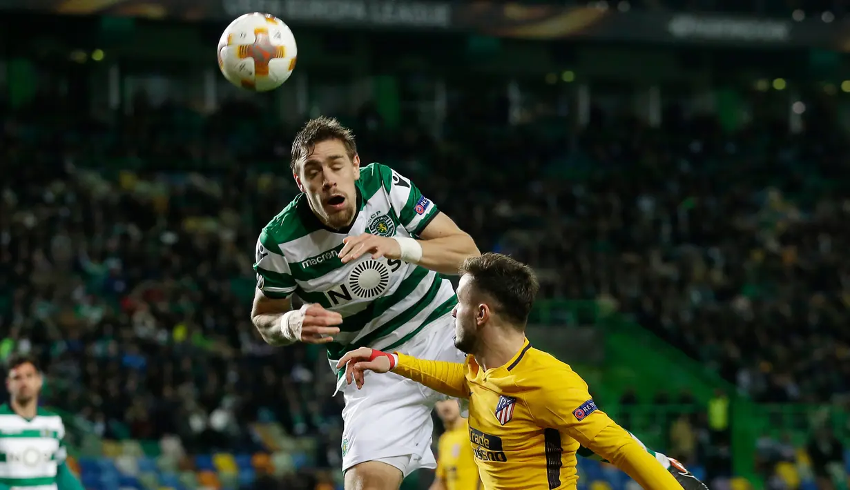 Pemain Sporting CP Sebastian Coates melompat merebut bola dari pemain Atletico Madrid Saul Niguez pada leg kedua perempat final Liga Europa di Estadio Jose Avalade, Jumat (13/4). Atletico Madrid tetap maju ke semifinal meski kalah 0-1  (AP/Armando Franca)