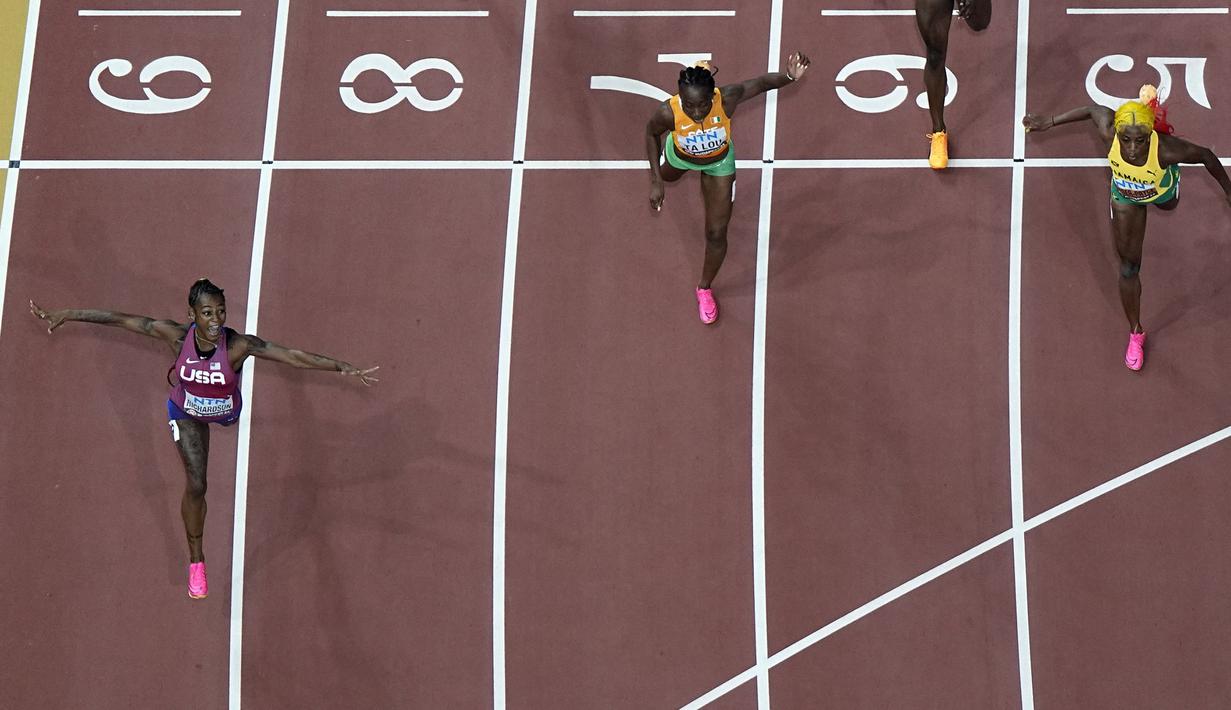 Pelari Amerika Serikat, Sha’Carri Richardson (kiri) melakukan selebrasi saat melewati garis finis pada final 100 meter putri Kejuaraan Dunia Atletik 2023 di National Athletics Centre, Budapest, Hungaria, pada 22 Augustus 2023. (AP Photo/David J. Phillip)