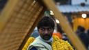 Seorang pedagang membawa karangan bunga jelang Festival Diwali di pasar bunga New Delhi, India, Minggu (31/10/2021). Festival Diwali atau Festival Cahaya dalam agama Hindu melambangkan kemenangan baik atas buruk. (Money SHARMA/AFP)