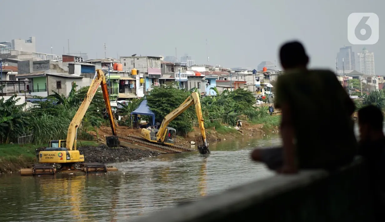 Petugas Dinas Sumber Daya Air dengan alat berat mengeruk sampah bercampur lumpur di aliran Banjir Kanal Barat, Jakarta, Rabu (14/10/2020). Pemprov DKI terus melakukan pengerukan serta pembersihan untuk mencegah pendangkalan juga mengantisipasi banjir di musim hujan. (Liputan6.com/Immanuel Antonius)