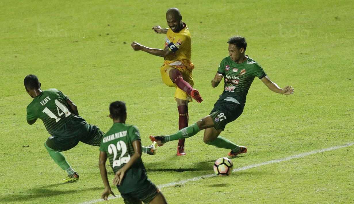 Pemain PS TNI berusaha menghalau tendangan striker Sriwijaya FC, Hilton Moreira, pada laga Liga 1 Indonesia di Stadion Pakansari, Bogor, Rabu, (25/10/2017). PS TNI menang 2-1 atas Sriwijaya FC. (Bola.com/M Iqbal Ichsan)