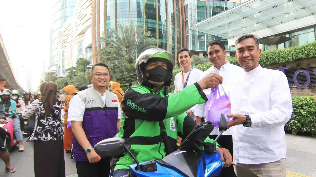 Sejumlah pejabat Bank Muamalat membagikan takjil kepada masyarakat yang melintas di depan Muamalat Tower, Jakarta, Kamis (13/4/2023).