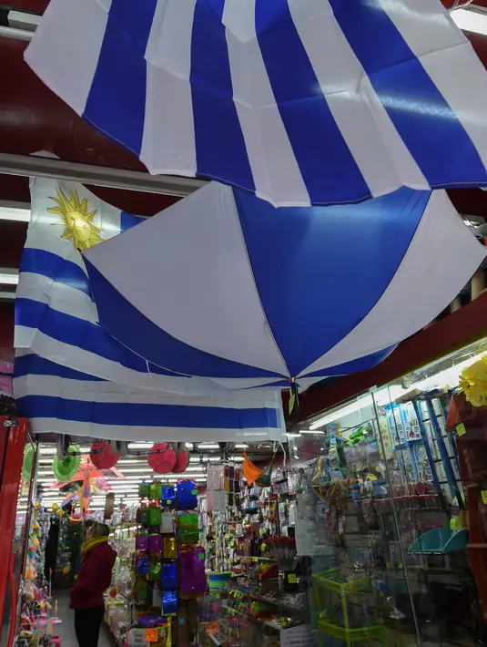 Bendera Uruguay dan merchandise terlihat di sebuah toko di Montevideo (4/7). Uruguay dan Prancis akan bertanding pada babak 8 besar Piala Dunia 2018 di Nizhny Novgorod Stadium, Rusia. AFP Photo/Miguel Rojo)