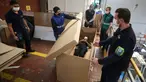 Rodolfo Gomez dan karyawannya mendemonstrasikan desain kardus mereka dapat berfungsi sebagai tempat tidur rumah sakit dan peti mati untuk pasien COVID-19 di Bogota, Kolombia, Jumat (8/5/2020). Perusahaan ini menanggapi kekurangan tempat tidur dan peti mati selama pandemi.  (AP/Fernando Vergara)